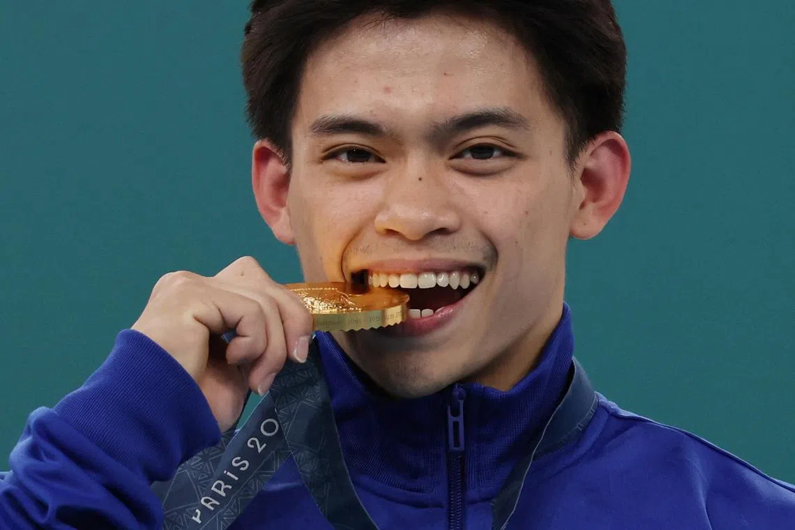 Paris 2024 Olympics - Artistic Gymnastics - Men's Vault Victory Ceremony - Bercy Arena, Paris, France - August 04, 2024.
Gold medallist Carlos Edriel Yulo of Philippines celebrates on the podium with his medal. REUTERS/Mike Blake