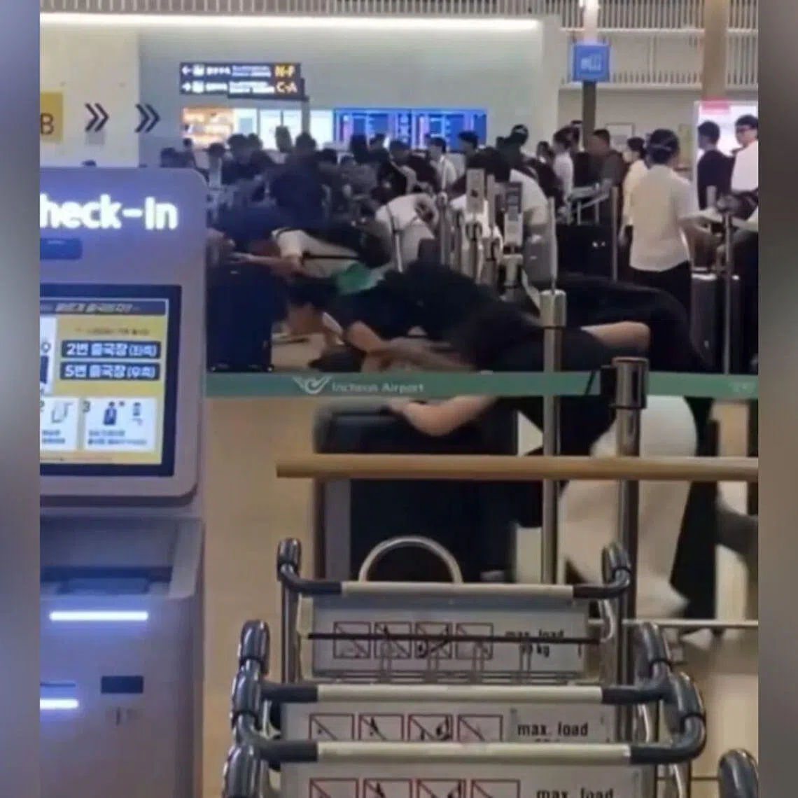 Instead of following the designated queue, passengers pushed luggage carts past retractable belt barriers arranged in a zigzag pattern in an apparent attempt to reach the airport counters first.