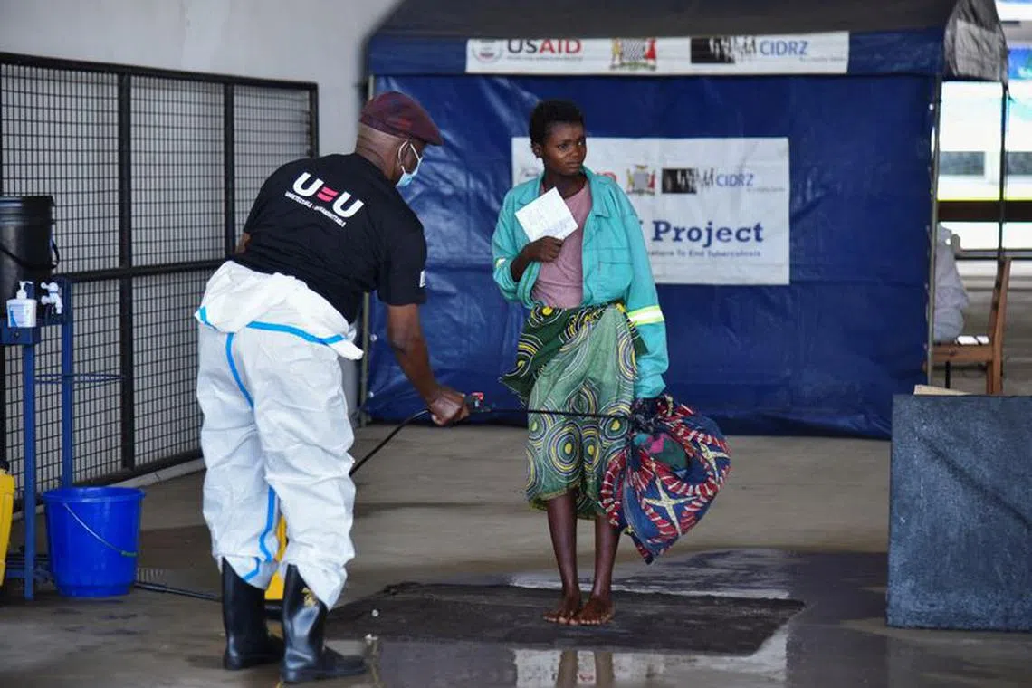 A woman is disinfected as she arrives at a temporary cholera treatment centre which has been set up to deal with the latest deadly cholera outbreak at the Heroes National Stadium in Lusaka, Zambia January 17, 2024 REUTERS/Namukolo Siyumbwa/File Photo