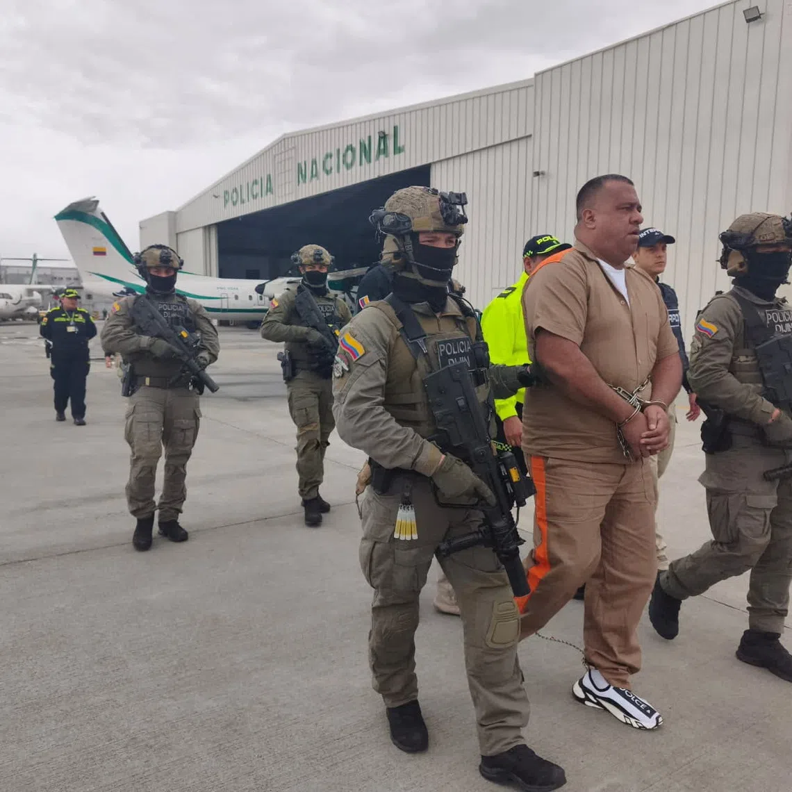 Geovany Andres Rojas, better known as \"Spider,\" an alleged leader of the Border Commands faction of the National Coordinator of the Bolivarian Army (CNEB), is escorted by Colombian police officers before being extradited to the United States, at a Colombian National Police air base in Bogota, Colombia, September 25, 2026. Colombian National Police/Handout via REUTERS