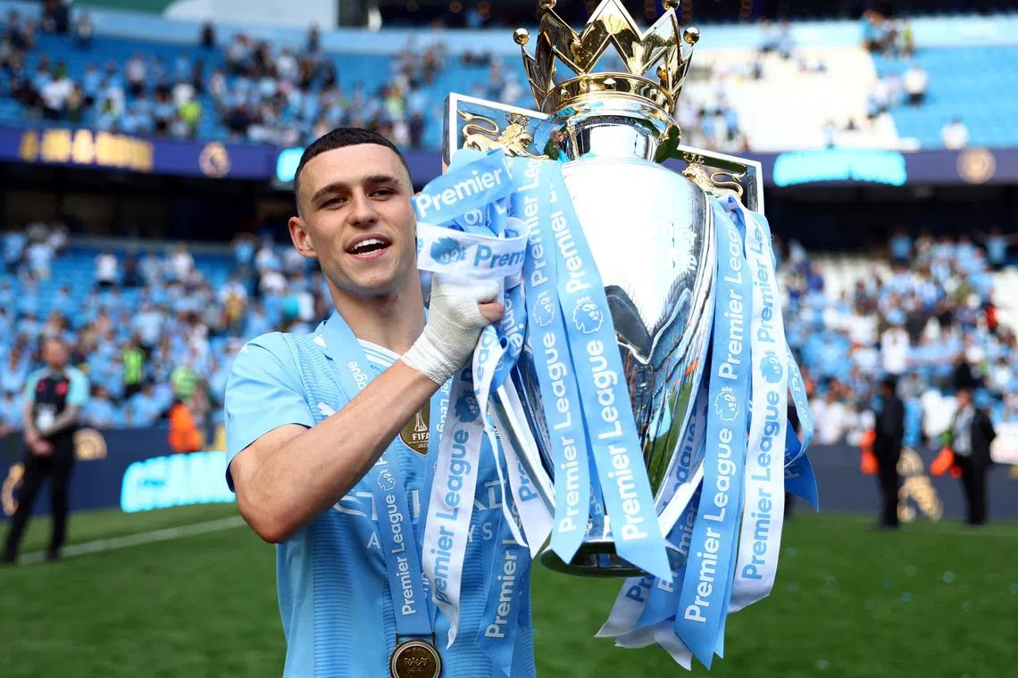 FILE PHOTO: Soccer Football - Premier League - Manchester City v West Ham United - Etihad Stadium, Manchester, Britain - May 19, 2024  Manchester City's Phil Foden celebrates with the trophy after winning the Premier League REUTERS/Molly Darlington//File Photo