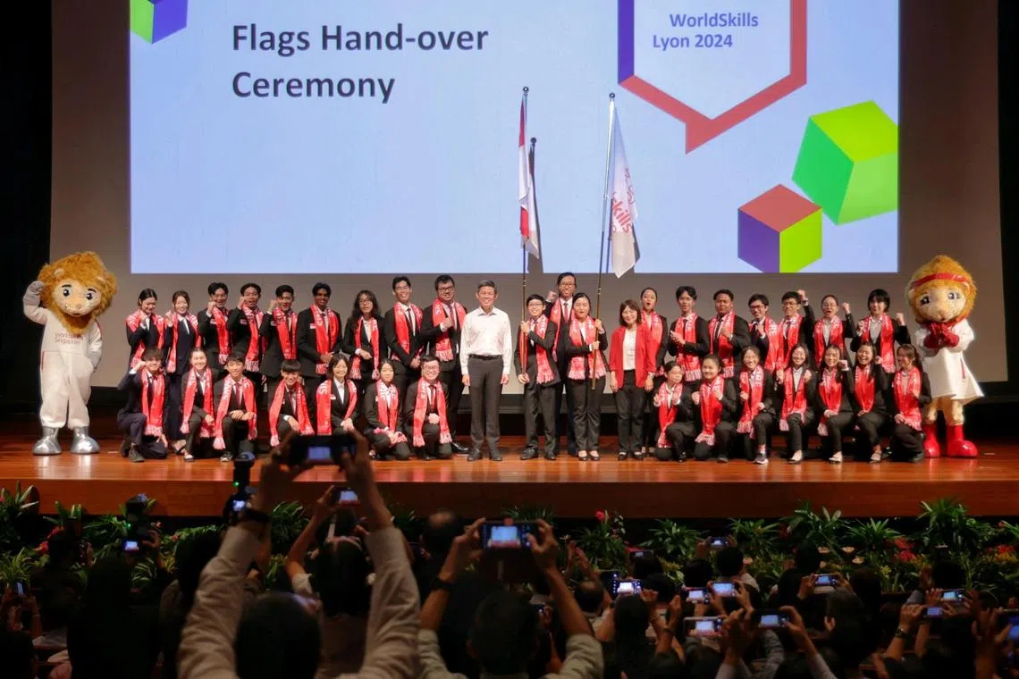 Education Minister Chan Chun Sing (white shirt) and CEO of ITE and official delegate for WorldSkills Singapore Low Khah Gek (red jacket) taking a group photo with members of Team Singapore bound for the upcoming 47th WorldSkills Competition (WSC) in Lyon, France, after officiating the symbolic handing over of Singapore and WorldSkills Singapore Flags during a send-off ceremony at Nanyang Polytechnic on Aug 29, 2024. The contingent  - comprising 35 youths from the Institute of Technical Education (ITE), the polytechnics and SBS Transit - will compete in 30 skill areas, at the upcoming 47th WorldSkills Competition (WSC) in Lyon, France, from 10 to 15 September 2024. ST PHOTO: KEVIN LIM etsend29