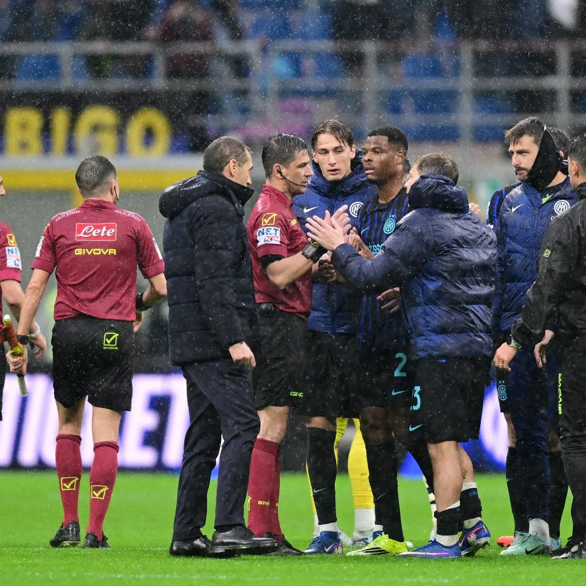 Soccer Football - Serie A - Inter Milan v Atalanta - San Siro, Milan, Italy - March 14, 2026 Inter Milan's Denzel Dumfries and Nicolo Barella with referee Gianluca Manganiello after the match REUTERS/Daniele Mascolo