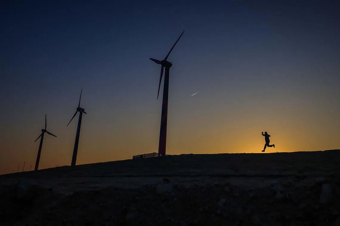 TOPSHOT - A man jogs in a parking lot near Expo City, the venue of the COP28 United Nations climate summit, in Dubai on December 6, 2023. (Photo by Karim SAHIB / AFP)