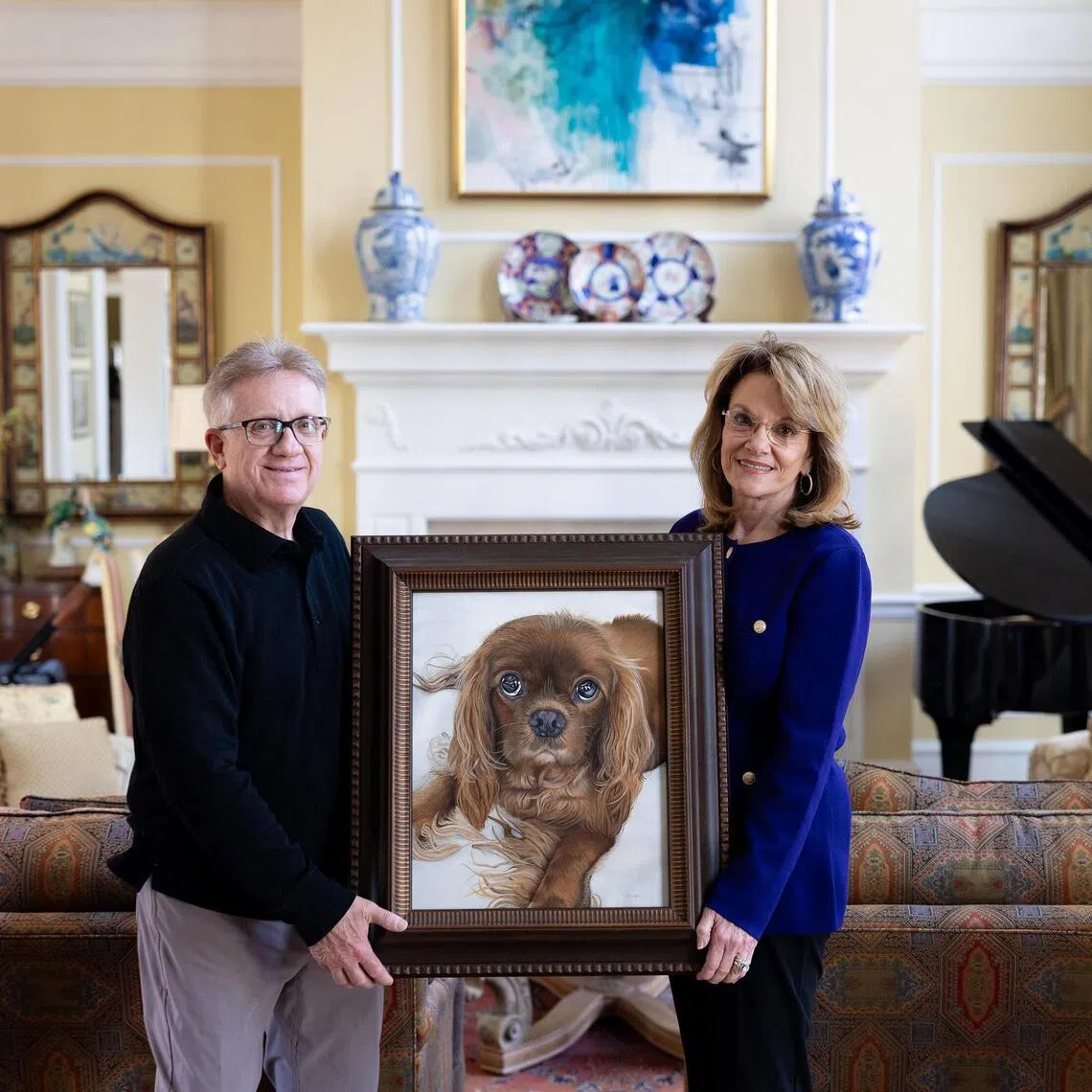 Tonya and Larry Smith hold a commissioned portrait of their King Charles Spaniel, Rusty, who passed away in November at their home in Quitman, Ga., on March 19, 2026. Commissioned pet portraits have been around for centuries, but now they’re reaching a much wider clientele. (Erich Martin/The New York Times)