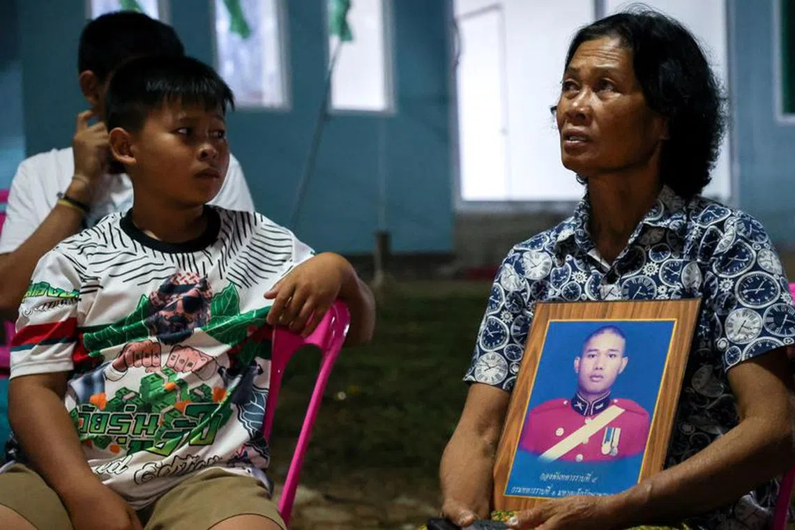 Noopar Pansa-ard, 63, holds up a picture of her son, Somkuan Pansa-ard, 39, a Thai labour who was killed in Israel in the ongoing conflict between Israel and the Palestinian Islamist group Hamas, at his house in Kalasin province, Thailand, October 10, 2023. REUTERS/Thomas Suen/File Photo