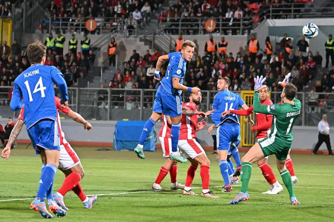 Italy's forward Mateo Retegui (centre) scores his team's first goal by a header on March 26, 2023.