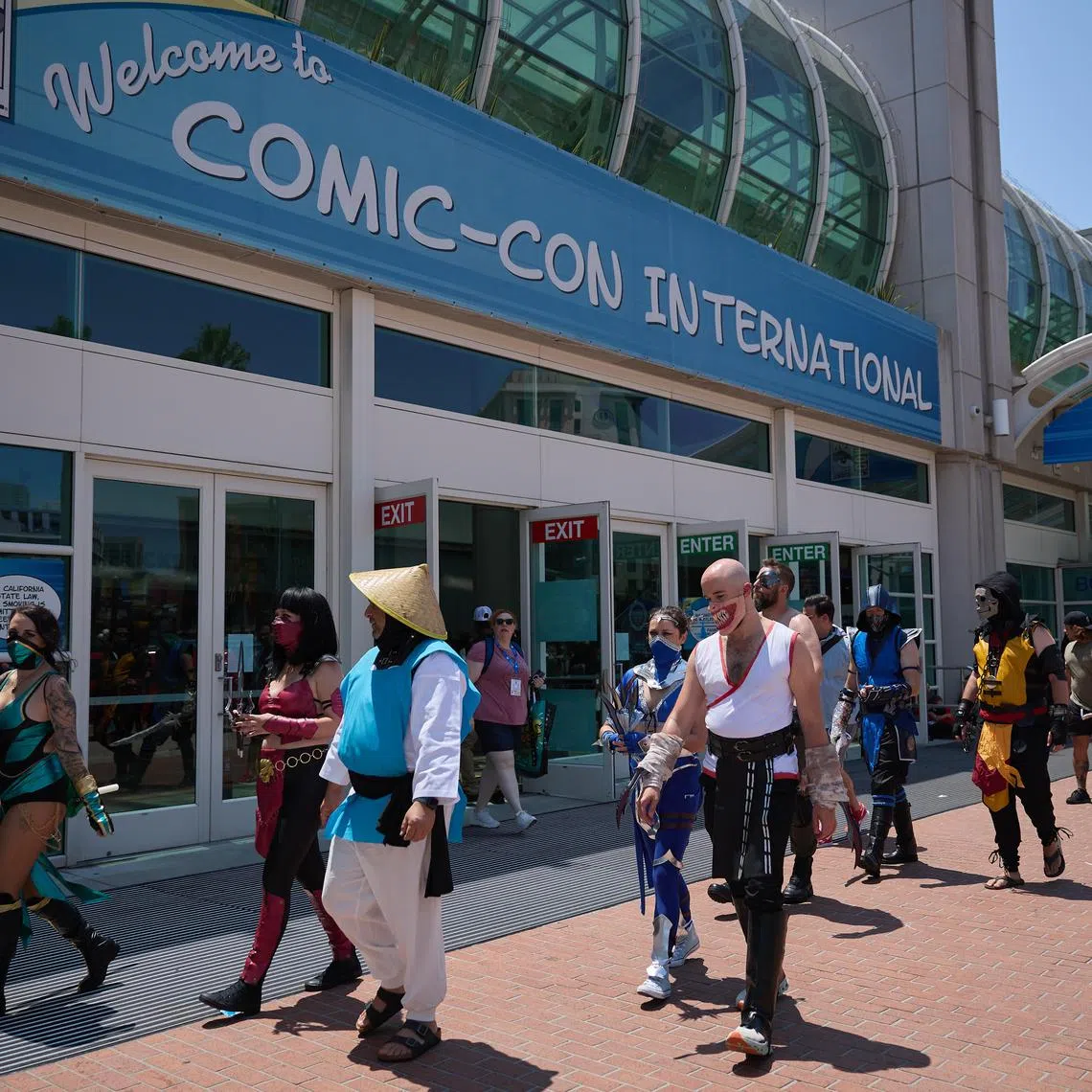People in cosplay walk by the entrance to Comic-Con International in San Diego on July 26. San Diego Comic-Con is one of the world’s largest pop culture events. 