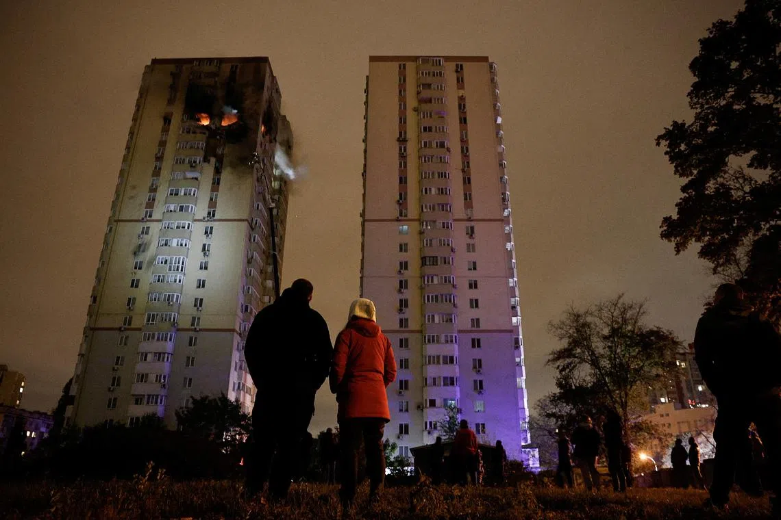 People watch a fire in an apartment building that was damaged during a Russian drone strike, amid Russia's attack on Ukraine, in Kyiv, Ukraine, October 25, 2024. REUTERS/Thomas Peter