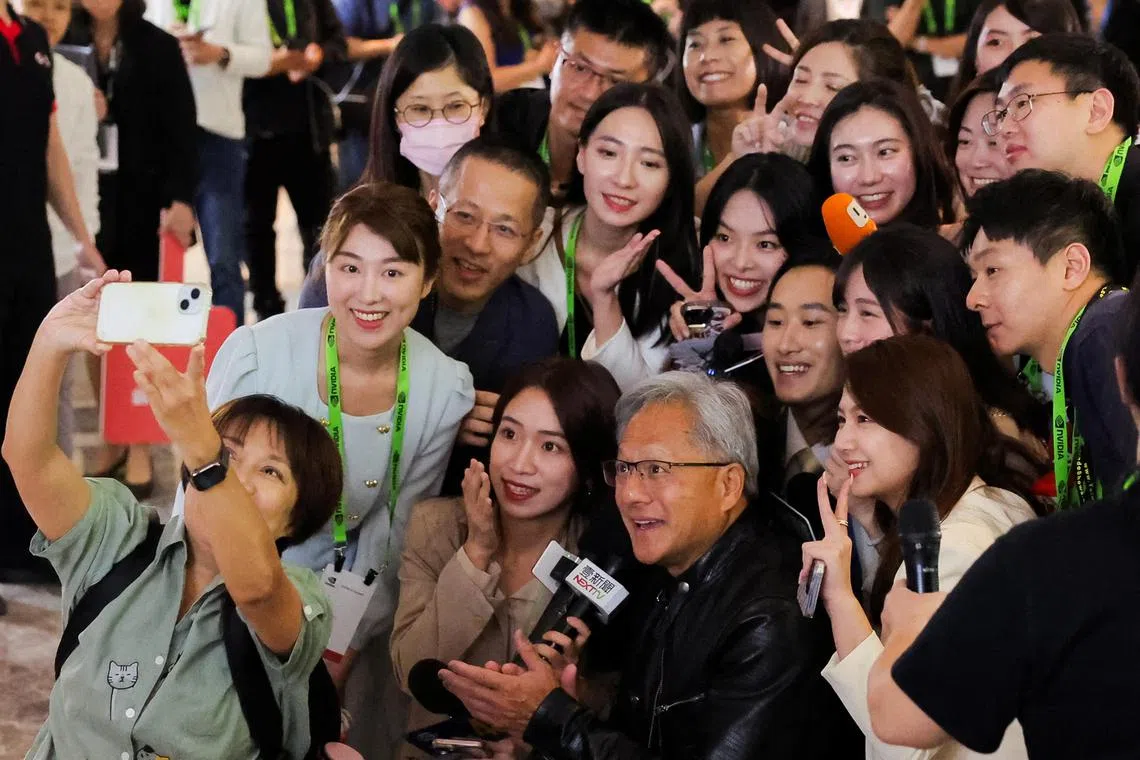 Nvidia CEO Jensen Huang poses for a selfie with members of the media at COMPUTEX forum in Taipei, Taiwan June 4, 2024. REUTERS/Ann Wang


