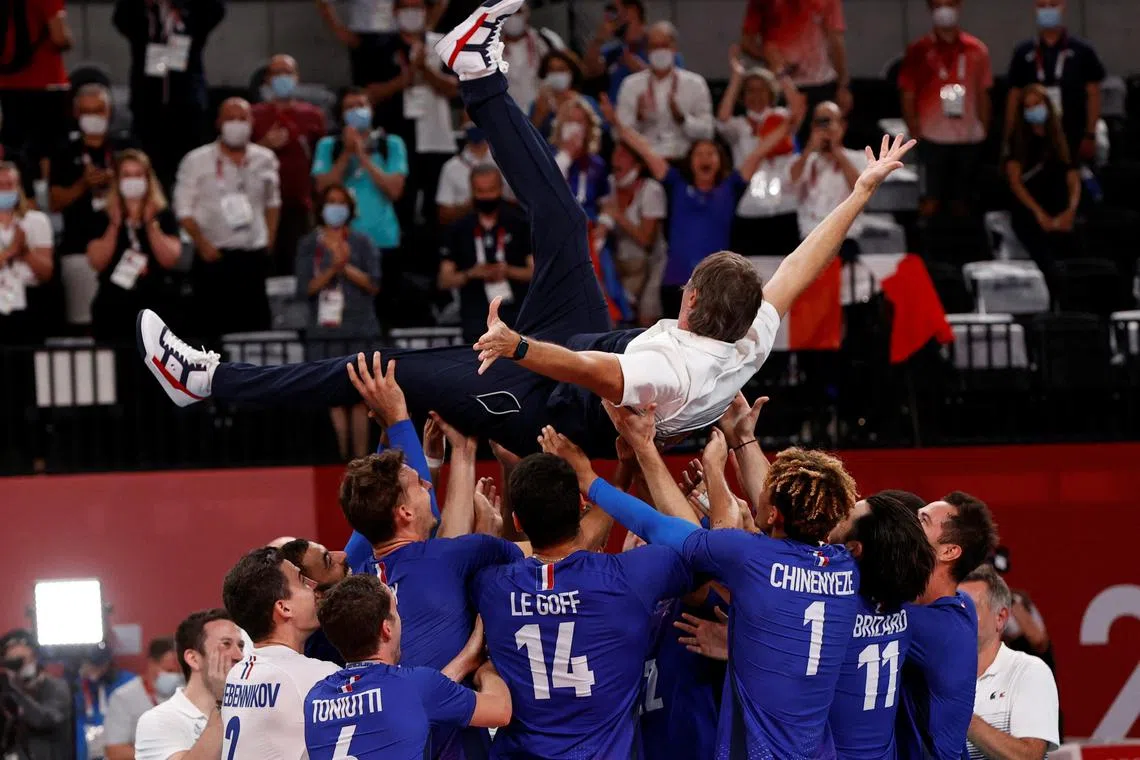 FILE PHOTO: Tokyo 2020 Olympics - Volleyball - Men's Gold medal match - France v The Russian Olympic Committee - Ariake Arena, Tokyo, Japan ? August 7, 2021. France coach Laurent Tillie is thrown into the air by team members as they celebrate after winning gold. REUTERS/Valentyn Ogirenko/File Photo