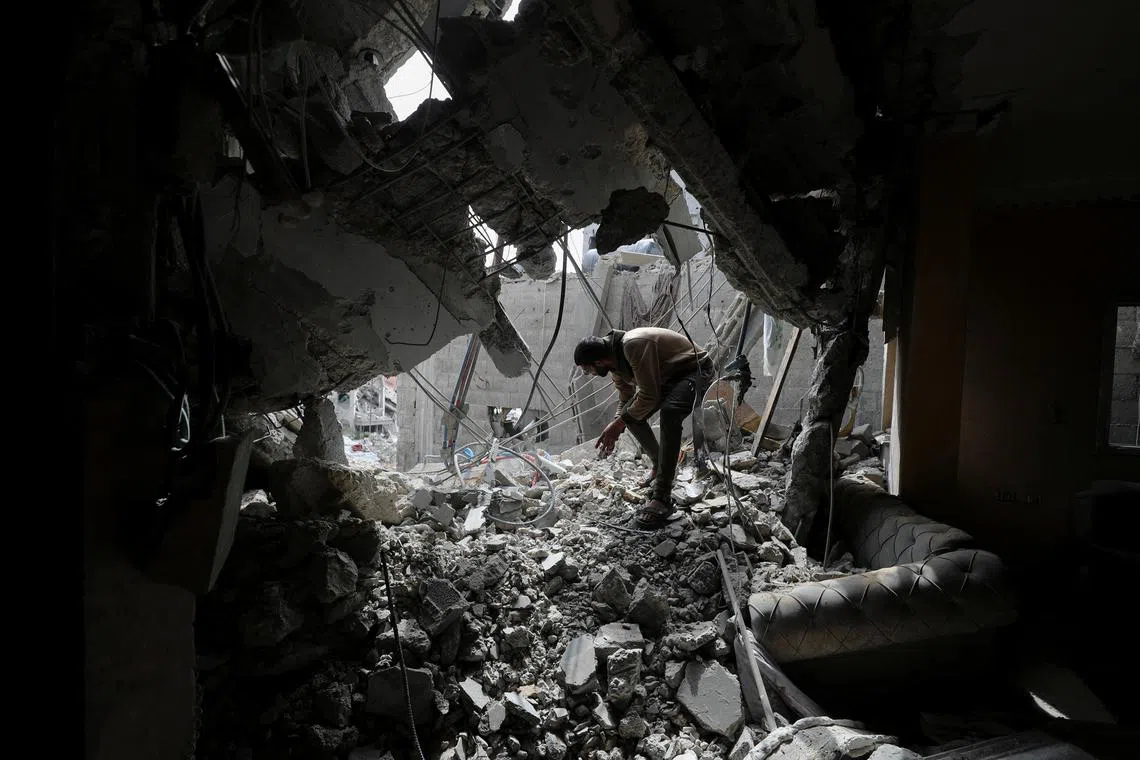 FILE PHOTO: A Palestinian man inspects the site of an Israeli strike on a house, in Gaza City, April 24, 2025. REUTERS/Mahmoud Issa/File Photo