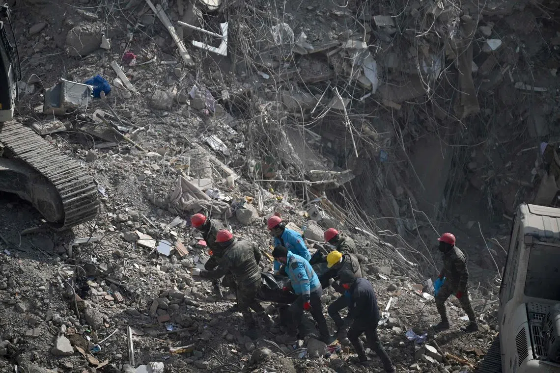 Search and rescue team evacuate a body from the rubble of collapsed buildings in Kahramanmaras, Turkey. 