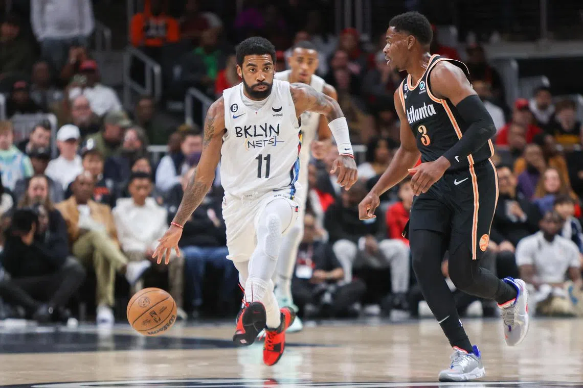 Brooklyn Nets guard Kyrie Irving is defended by Atlanta Hawks guard Aaron Holiday at State Farm Arena.