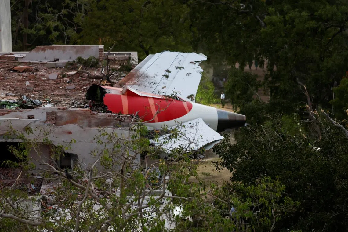The tail of an Air India Boeing 787 Dreamliner plane that crashed is seen stuck on a building after the incident in Ahmedabad, India, on June 12.
