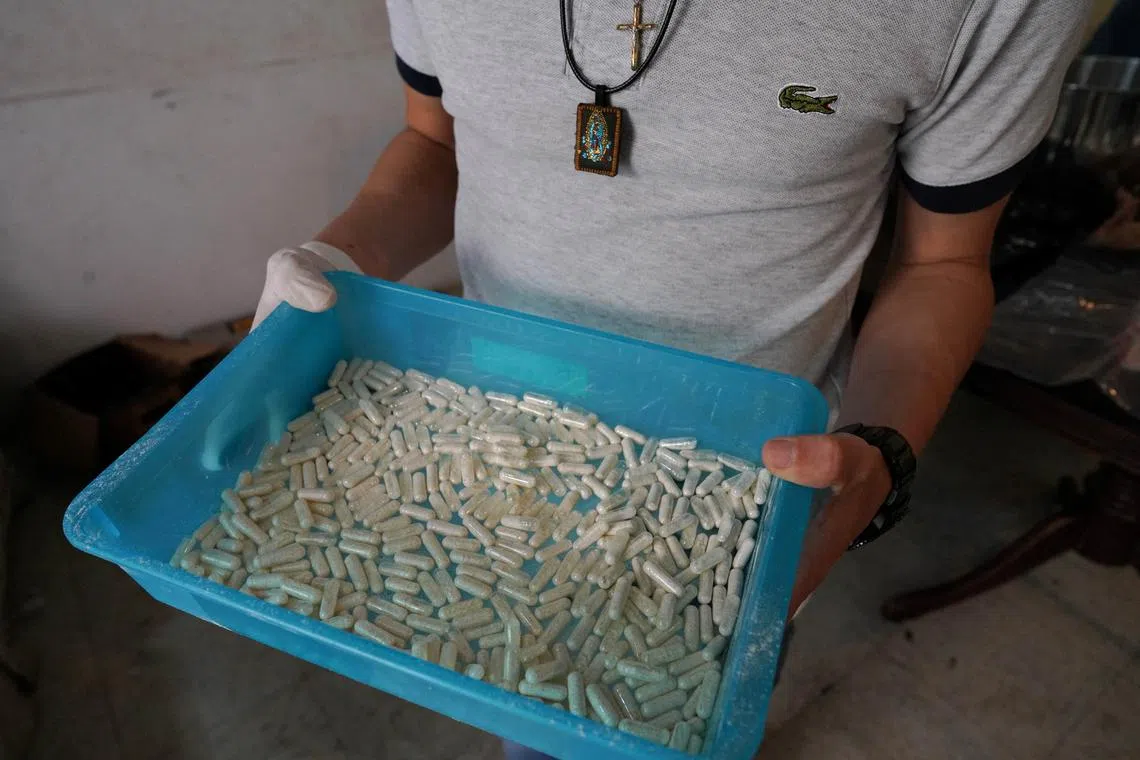 FILE PHOTO: A member of the Sinaloa Cartel shows capsules with methamphetamine in a safe house in Culiacan, Mexico, April 4, 2022. REUTERS/Alexandre Meneghini/File Photo