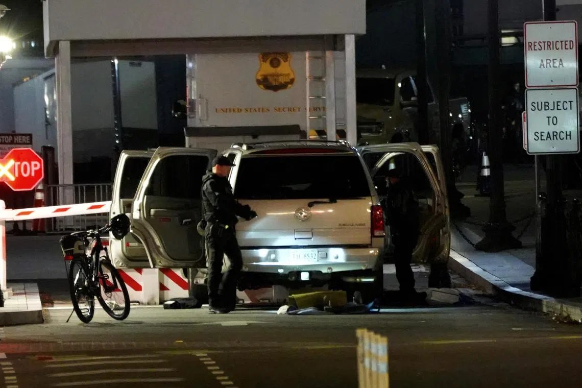 Members of the US Secret Service work at the site of a vehicle crash at a perimeter gate of the White House.