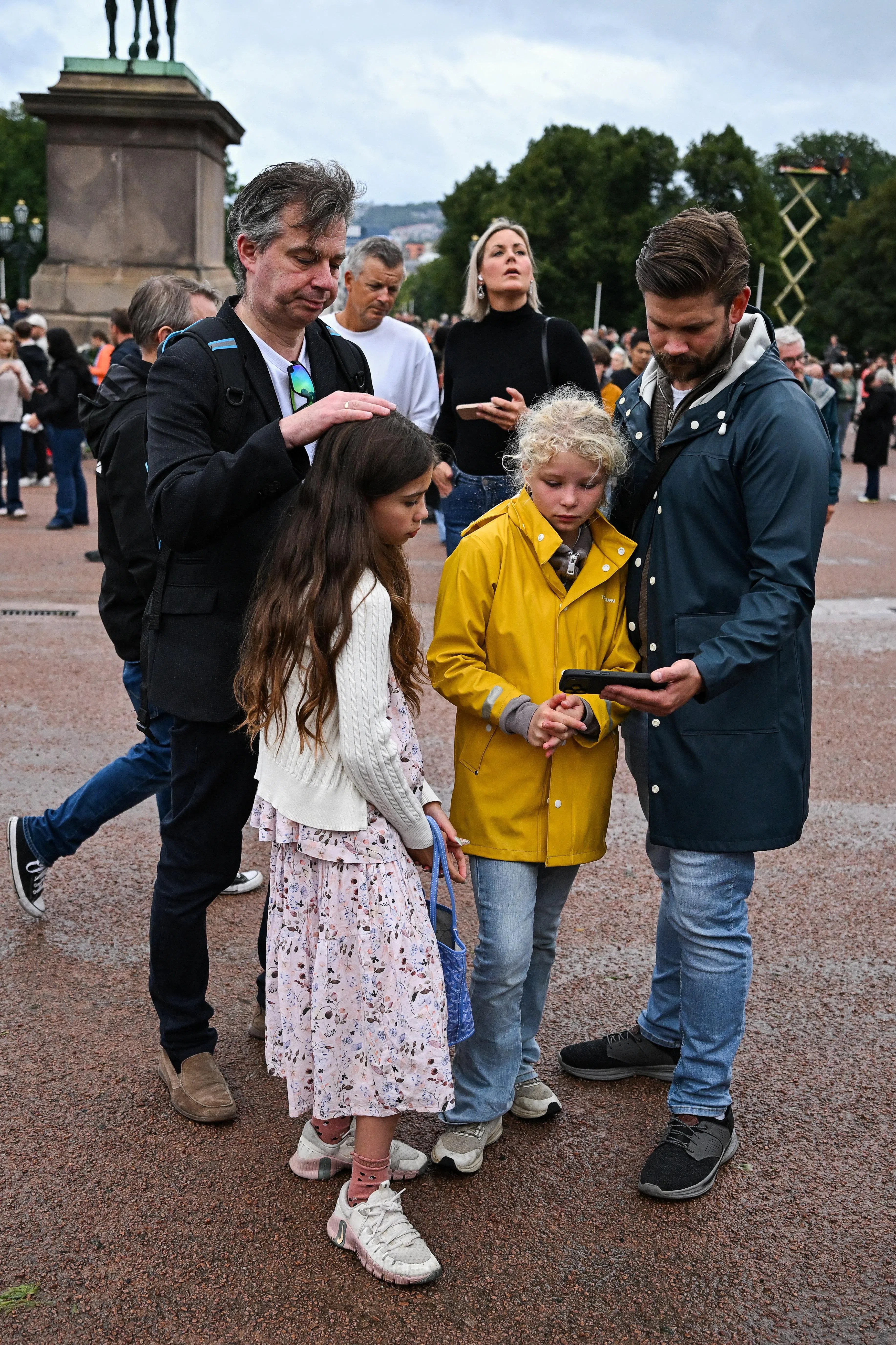 People watch King Haakon’s address to the nation outside the Royal Palace in Oslo, Norway, on Aug 29.