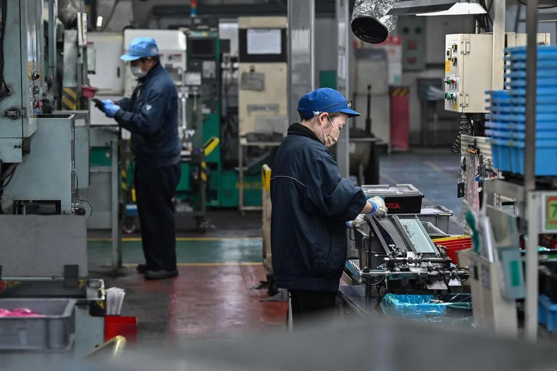 Employees inspect auto parts on the factory floor of supplier Asahi Tekko in the city of Hekinan, Aichi prefecture on April 1, 2025. Japan, where 10 percent of all jobs are related to the automobile sector, is bracing itself as US President Donald Trump prepares to impose an additional 25 percent tariff on vehicle and auto part imports, including those from Japan. (Photo by Richard A. Brooks / AFP) / To go with AFP story US-Japan-tariff-trade-diplomacy-automobile, REPORTAGE by Hiroshi HIYAMA