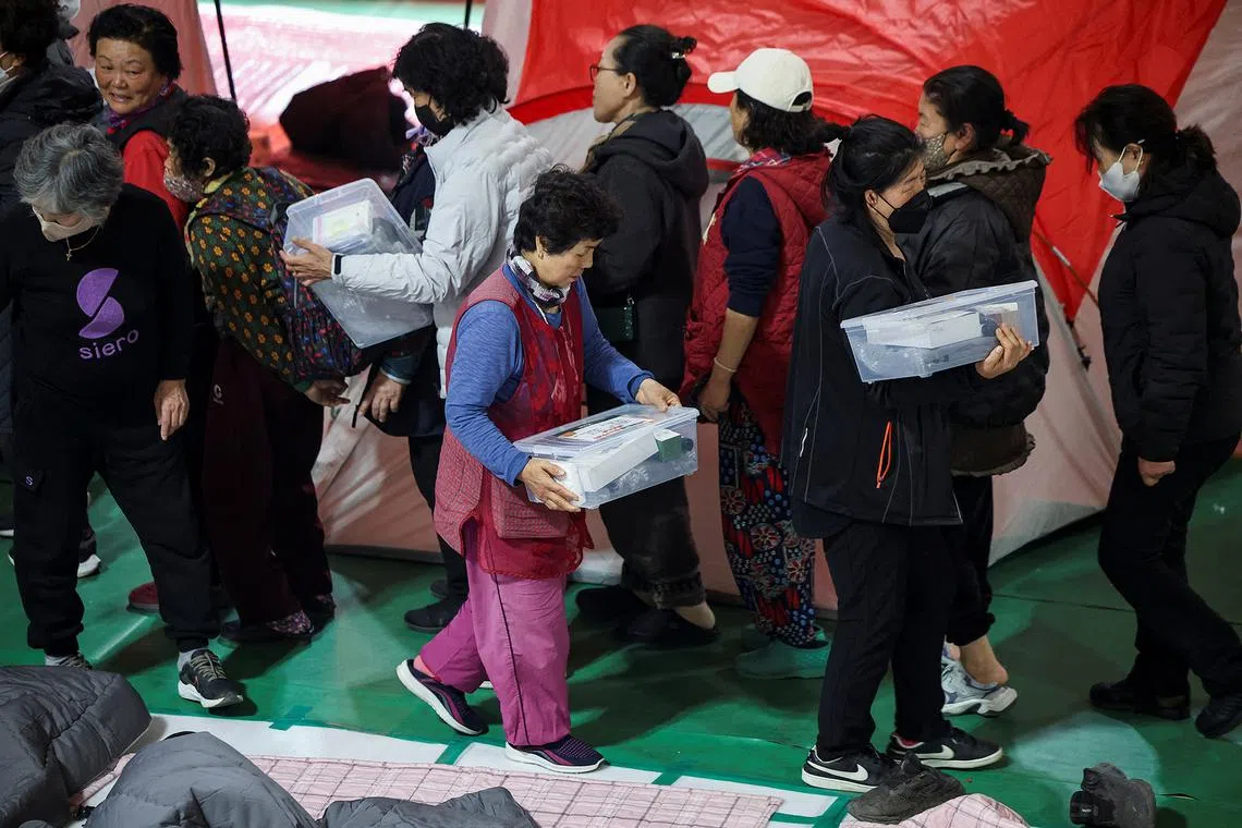 People queuing to receive supplies at a shelter in Yeongyang, South Korea, on March 26, 2025. 