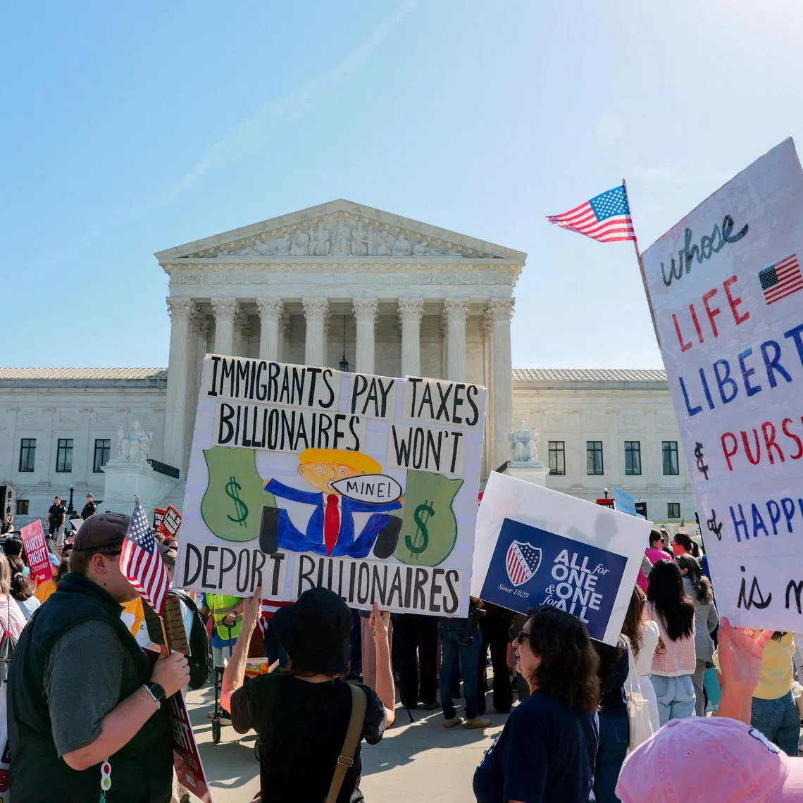 Demonstrators hold placards outside the U.S. Supreme Court building as the court hears oral arguments on the legality of the Trump administration's effort to limit birthright citizenship for the children of immigrants, in Washington, D.C., U.S., April 1, 2026. REUTERS/Kylie Cooper
