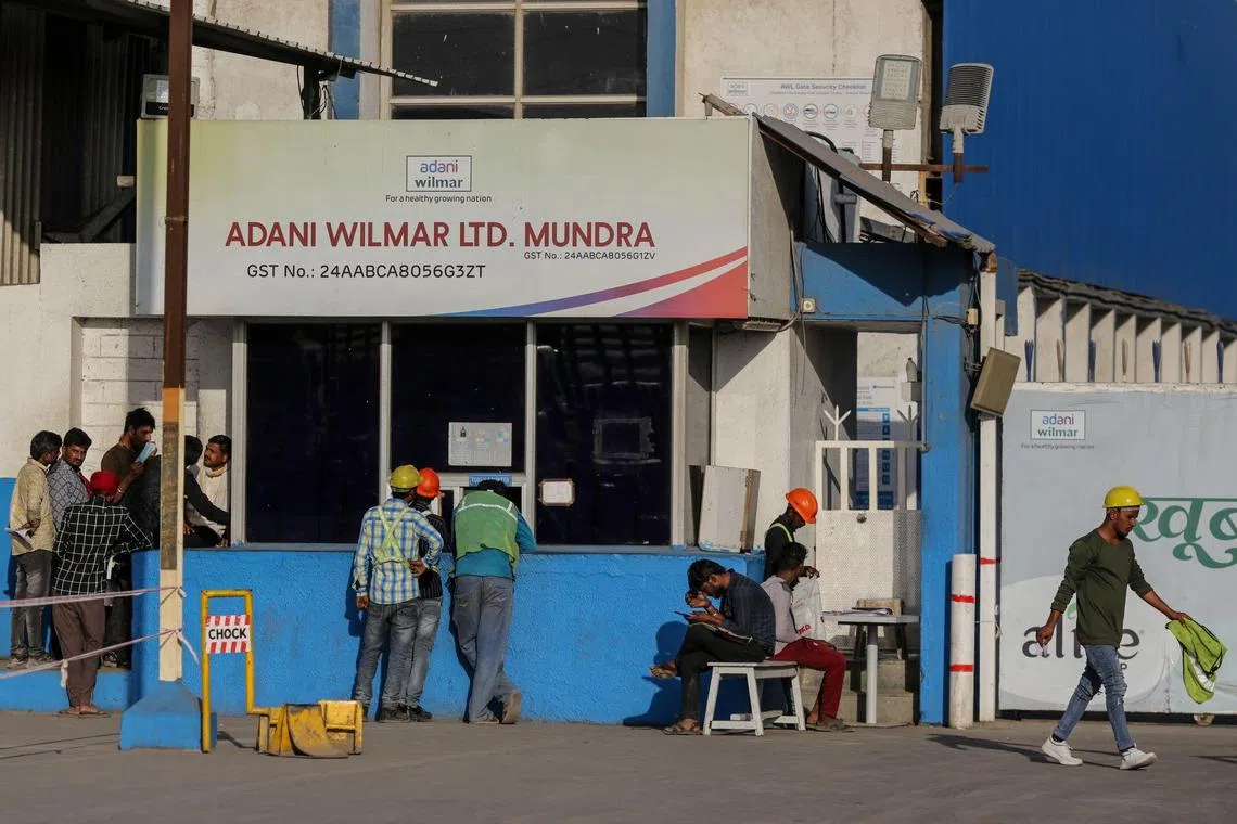 Workers outside the Adani Wilmar Ltd of the Adani Group edible oil manufacturing unit in Mundra, Gujarat, India, on Feb 8.