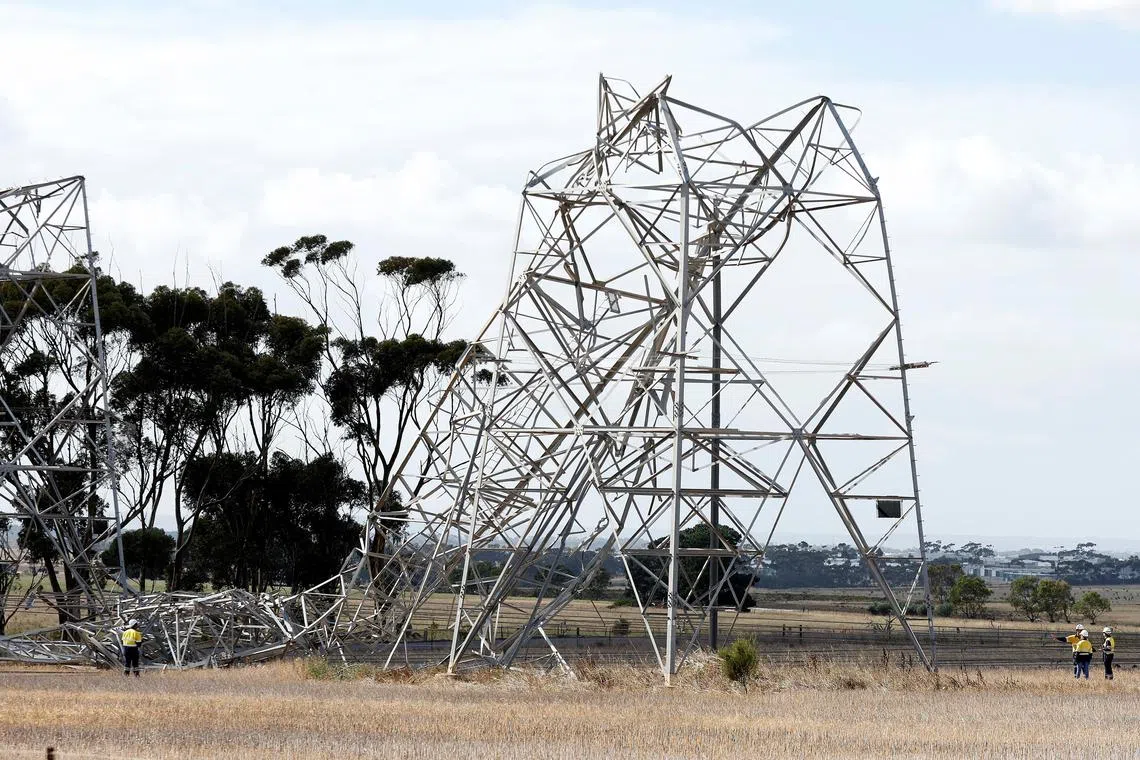 Workers inspect damaged transmission towers at Anakie in Victoria, Australia February 14, 2024. Hundreds of thousands of residents across Australia's Victoria state remained without power on Wednesday after wild weather knocked down transmission lines and sparked bushfires that injured five firefighters. AAP Image/Con Chronis via REUTERS  ATTENTION EDITORS - THIS IMAGE WAS PROVIDED BY A THIRD PARTY. NO RESALES. NO ARCHIVE. NEW ZEALAND OUT. NO COMMERCIAL OR EDITORIAL SALES IN NEW ZEALAND. AUSTRALIA OUT. NO COMMERCIAL OR EDITORIAL SALES IN AUSTRALIA  