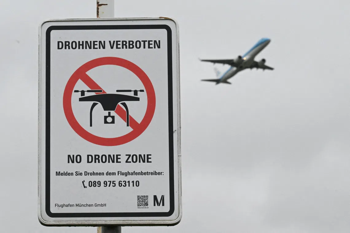 FILE PHOTO: A sign with a drone ban is displayed outside the airport in Munich, Germany October 6, 2025. REUTERS/Angelika Warmuth/File Photo