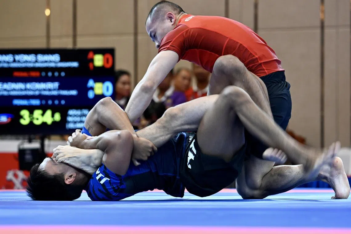 Singapore's ju-jitsu exponent Tang Yong Siang pinning Thailand's Keadnin Komrit during the men's ne-waza nogi 56kg preliminary rouind bout on May 7.
