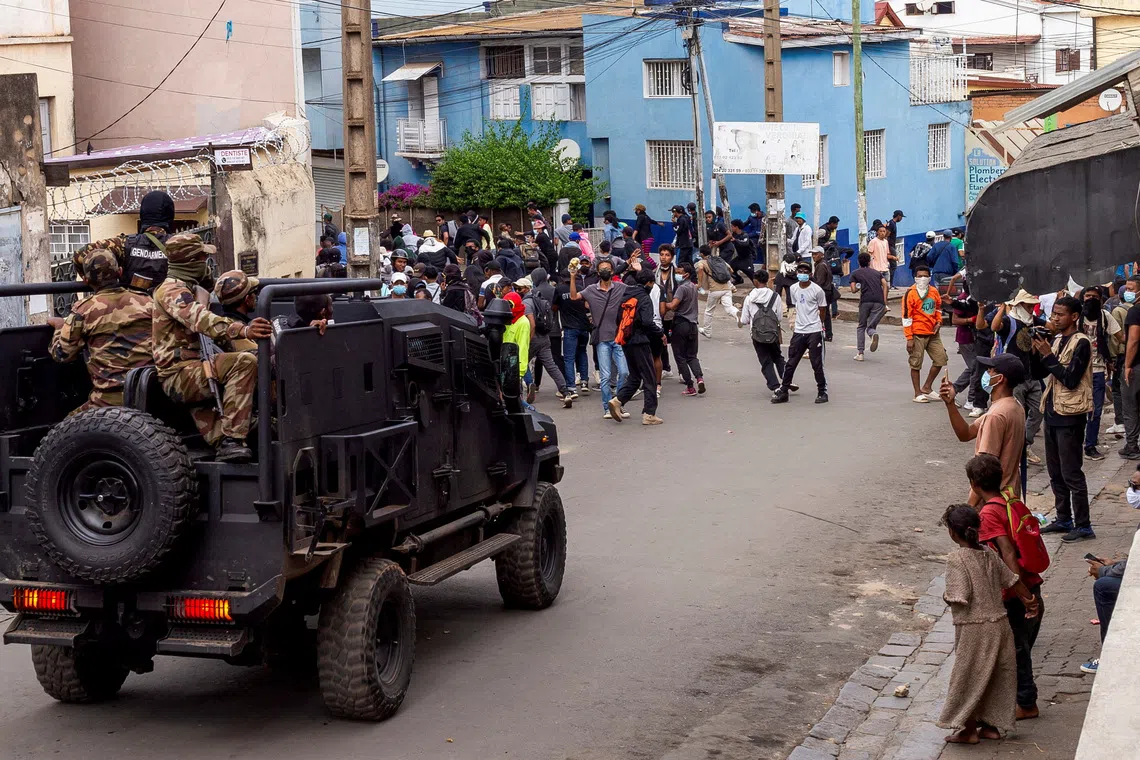 Protesters watch as riot police officers drive past during a demonstration against frequent power outages and water shortages, in the capital Antananarivo, Madagascar, October 1, 2025. REUTERS/Zo Andrianjafy