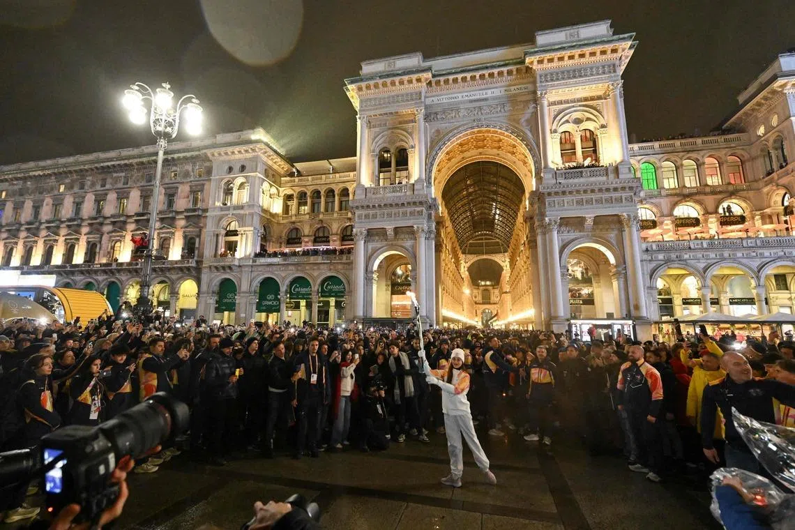 Italian ballet dancer Nicoletta Manni (C) carrying the Olympic Flame as she arrives at the Piazza Duomo prior to the opening of the Milano Cortina 2026 Winter Olympic Games in Milan, Italy, on Feb 5, 2026. 