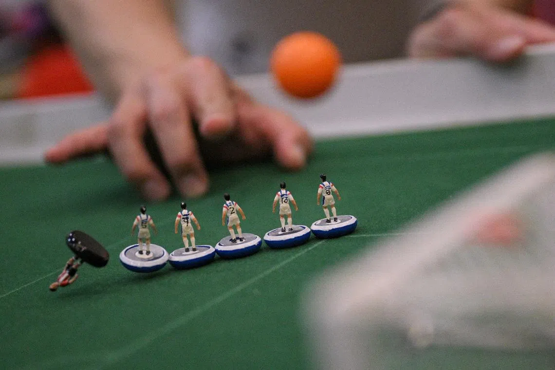 People play Subbuteo, a classic tabletop football game, at a community centre on June 18, 2026.