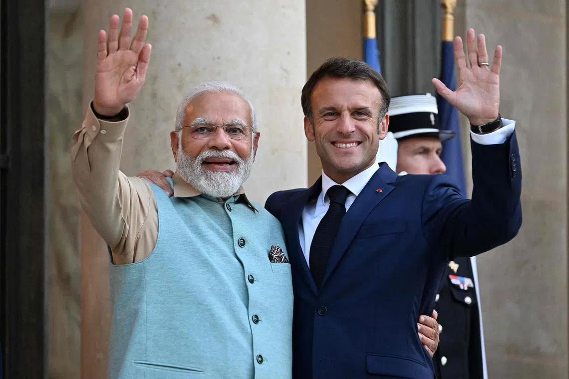 French President Emmanuel Macron (right) welcomes Indian Prime Minister Narendra Modi for a dinner at the Elysee Palace in Paris on July 13.