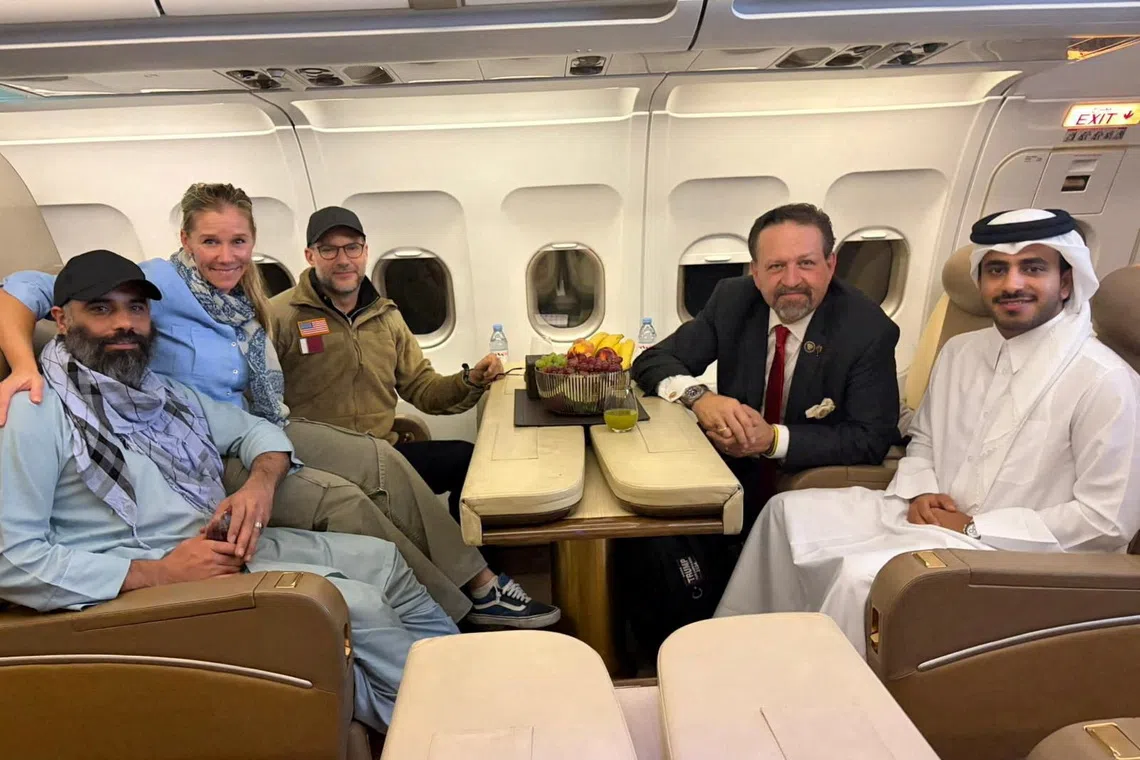 Amir Amiri, who had been detained in Afghanistan since December 2024, poses for a picture alongside Adam Boehler, the U.S. special envoy for hostage response, Sebastian Gorka, the deputy assistant to the U.S. president and senior director for counterterrorism, and a Qatari diplomat, on a plane from Kabul Afghanistan, September 28, 2025. Qatari Diplomat/Handout via REUTERS