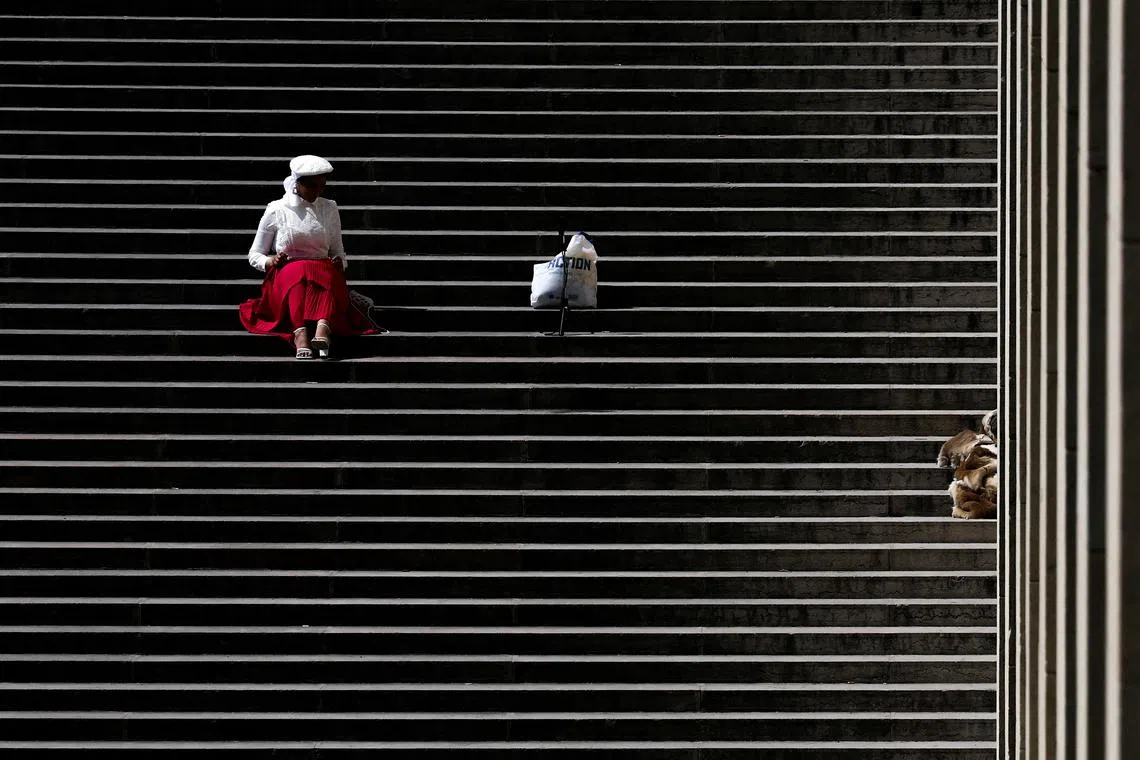 A woman taking a selfie at the steps of the Trocadero square on on a warm and sunny spring day in Paris, France, on June 19, 2025. 