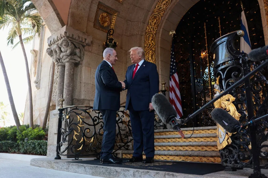 US President Donald Trump greets Israeli Prime Minister Benjamin Netanyahu in Palm Beach, Florida, in December. Israel has largely been left out of talks to reach an initial deal to halt the Iran war.