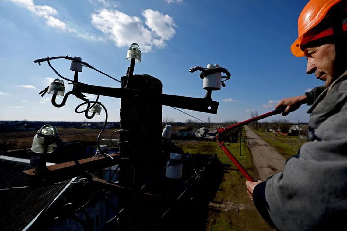 FILE PHOTO: Sergij Ovchynnikov, a worker of electricity company Khersonoblenergo, replaces the power cord of a pylon amid Russia's invasion of Ukraine, in Pravdyne, Kherson region, Ukraine, February 23, 2023. REUTERS/Lisi Niesner/File Photo
