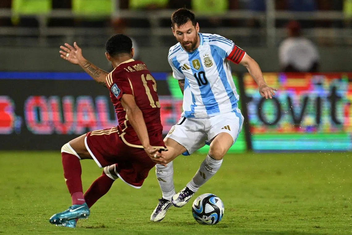 Argentina forward Lionel Messi and Venezuela midfielder Jose Martinez fight for the ball during their World Cup qualifier.