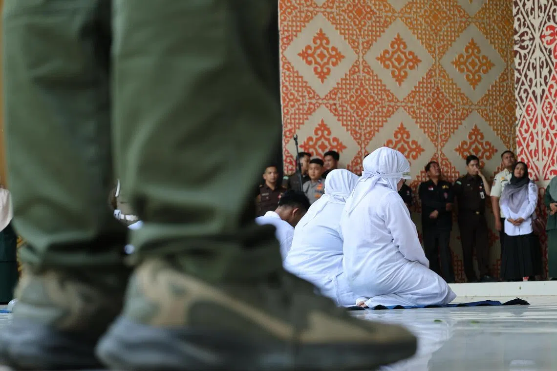 Violators at a public flogging for violating syariah law in Banda Aceh, Indonesia, on July 2.