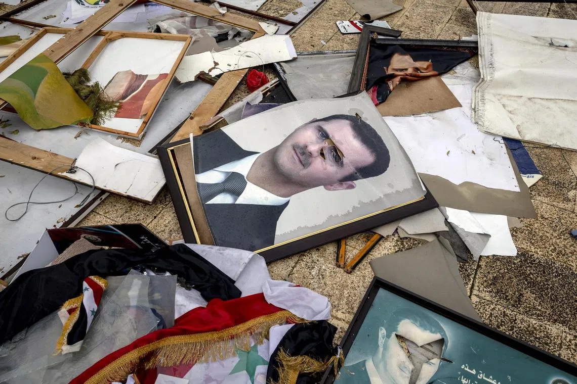 Defaced portraits of ousted Syrian president Bashar al-Assad, outside a municipal building in Aleppo, Syria, on Dec 12.