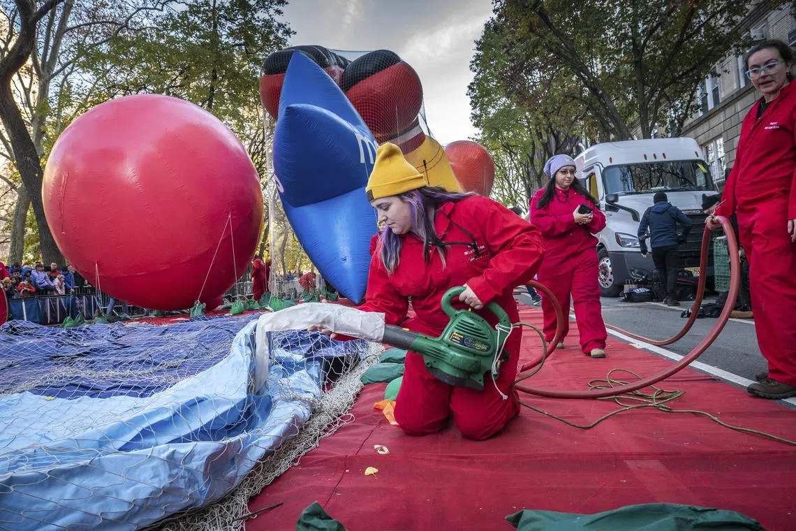 Workers inflate balloons during the MacyÕs Thanksgiving Parade balloon inflation event outside the Museum of Natural History in Manhattan, on Wednesday, Nov. 27, 2024. Spectators attending MacyÕs Thanksgiving Day Parade on Thursday can expect light, steady rain throughout the event, according to the National Weather Service. (Graham Dickie/The New York Times) 