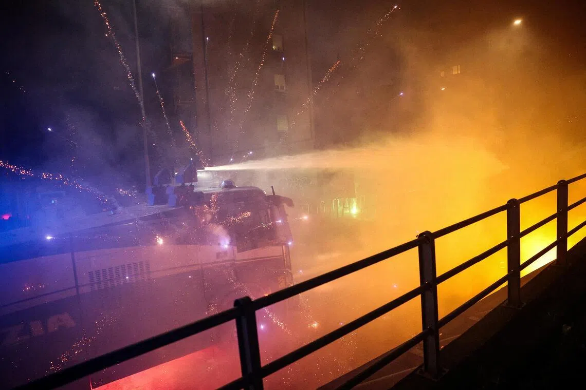 Fireworks exploding near a police water cannon used against protesters in Milan on Feb 7. Demonstrators had tried to block a road leading to the Santa Giulia Arena, in protest over the environmental, economic and social impact of the Winter Olympics.