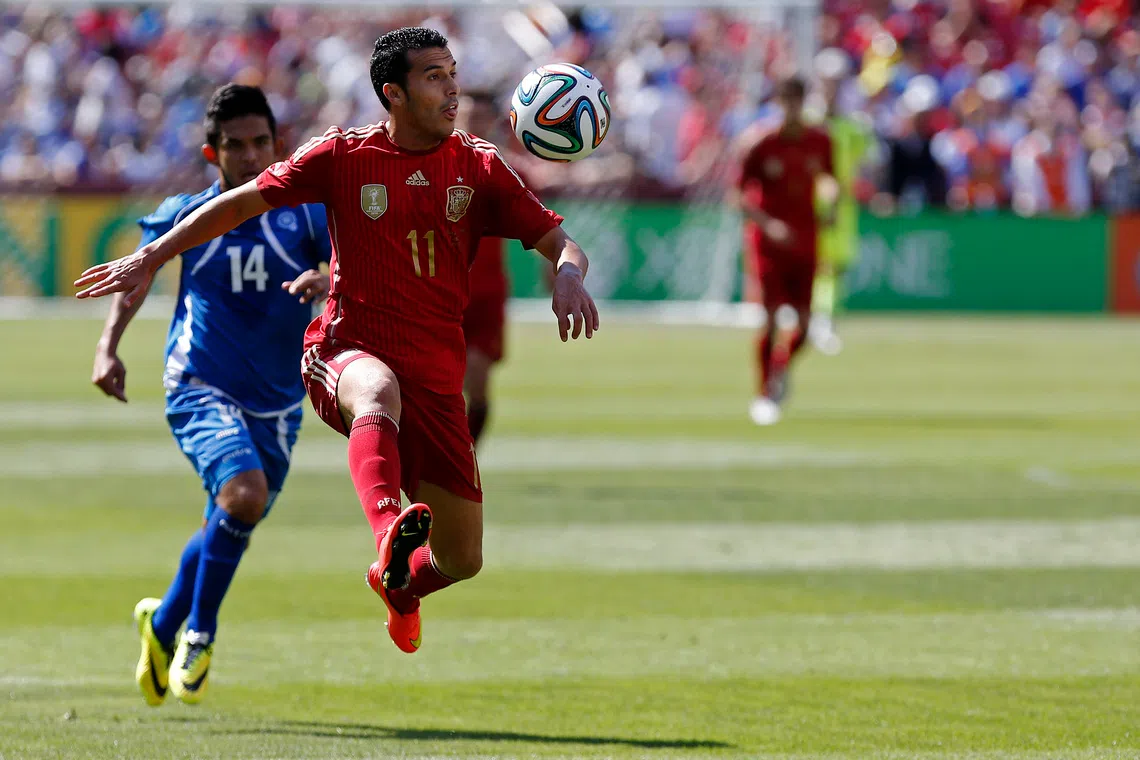 Jun 7, 2014; Landover, MD, USA; Spain midfielder Pedro Rodriguez (11) receives a pass in front of El Salvador forward Andres Flores (14) in the first half at FedEx Field. Spain won 2-0. Mandatory Credit: Geoff Burke-USA TODAY Sports