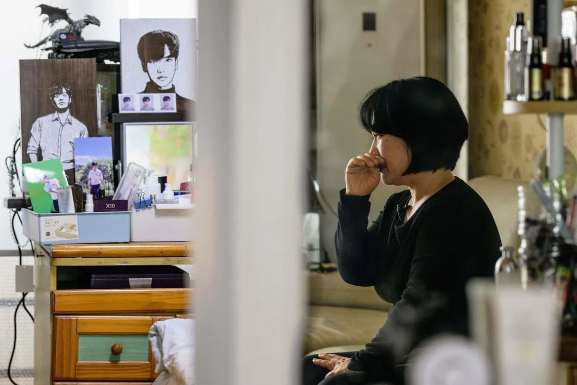 Madam Cho Mi-eun (R reflected in mirror crying at their family home in Seoul on March 20.