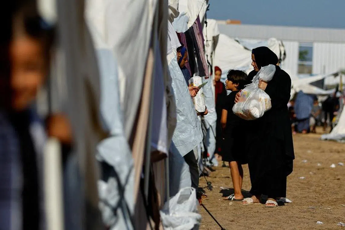FILE PHOTO: Palestinians, who fled their houses amid Israeli strikes, take shelter at a tent camp at a United Nations-run centre, after Israel's call for more than 1 million civilians in northern Gaza to move south, in Khan Younis in the southern Gaza Strip, October 26, 2023. REUTERS/Ibraheem Abu Mustafa/File Photo
