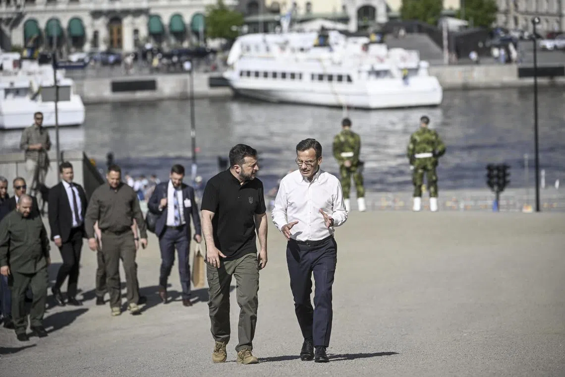 Ukrainian President Volodymyr Zelensky (left) and Swedish Prime Minister Ulf Kristersson walking to the Stockholm Palace to meet Sweden's King Carl Gustaf, on May 31.