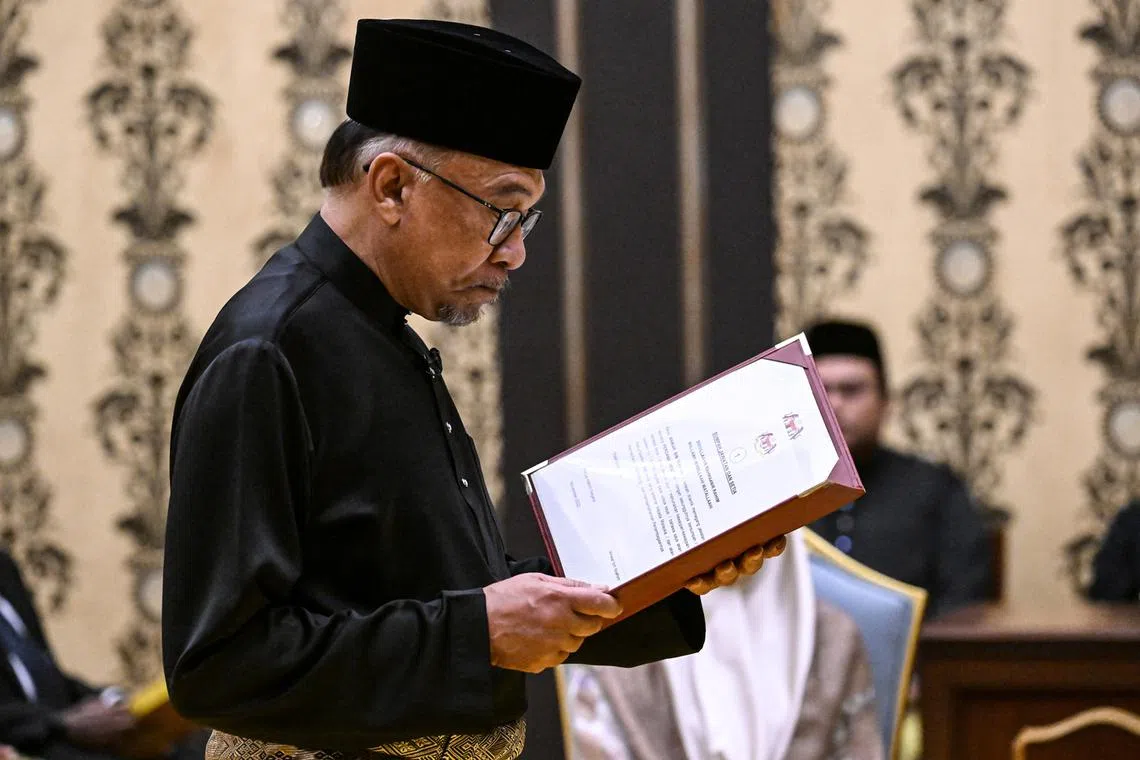 Malaysia's newly appointed Prime Minister Anwar Ibrahim takes the oath during the swearing-in ceremony at the Istana Negara (National Palace) in Kuala Lumpur, Malaysia,  Nov 24, 2022. 
