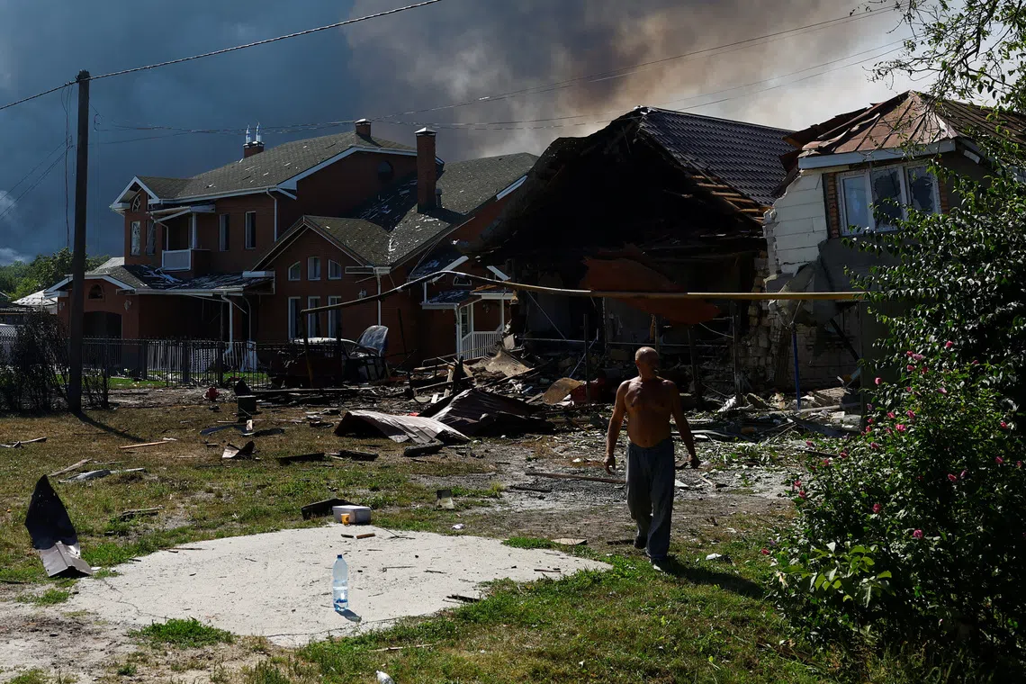 A resident walks next to houses damaged during a Russian drone strike, amid Russia's attack on Ukraine, in Kyiv region, Ukraine, August 27, 2026. REUTERS/Valentyn Ogirenko
