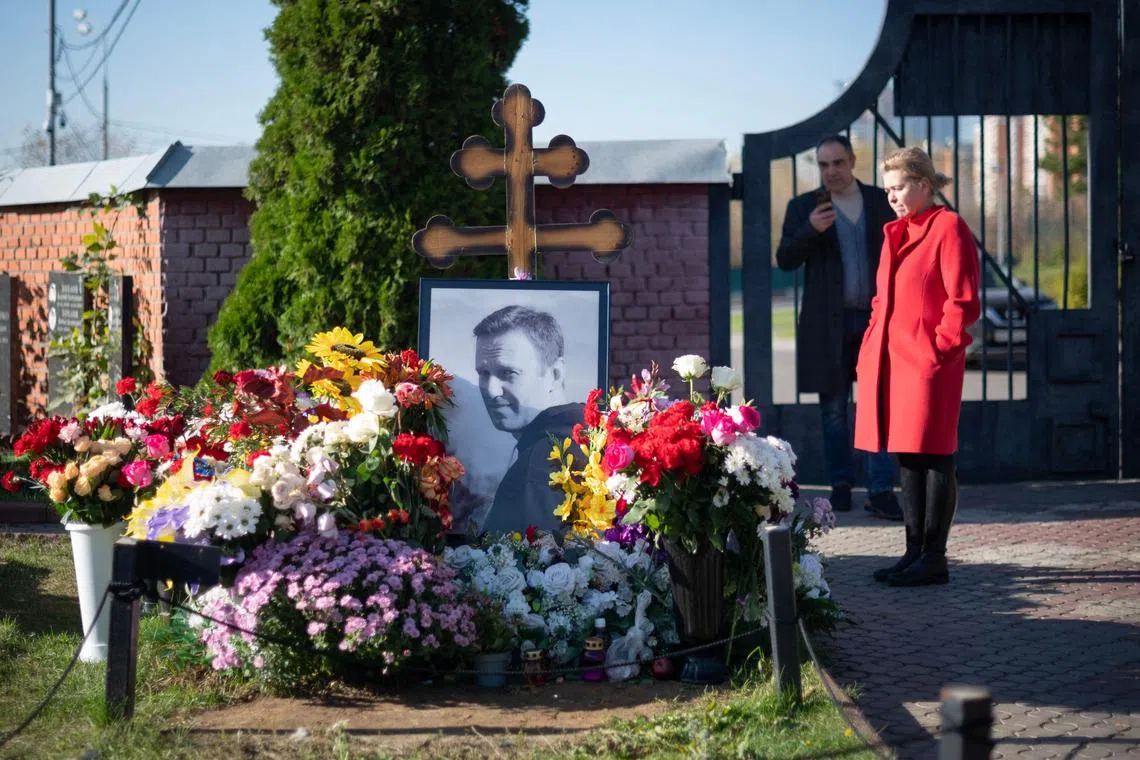 This picture taken on Oct 21, 2024, shows people standing by Russian opposition leader Alexei Navalny's grave at the Borisovo cemetery in Moscow. He died in February aged 47. 