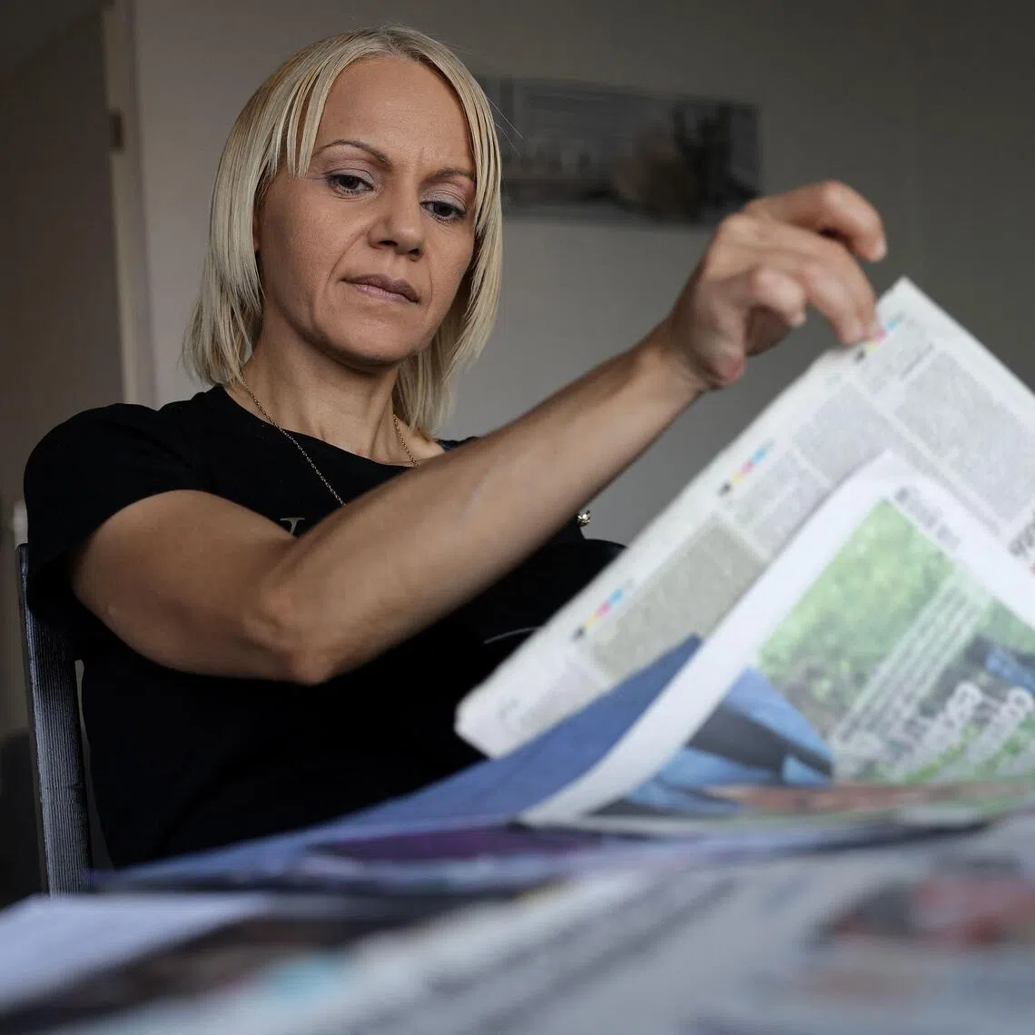 Moroccan-born Yasmina Tellal, a 42-year-old Moroccan woman, consults press clippings in southwestern France on August 15, 2025. #MeToo may have helped change the landscape for women in Hollywood and in the boardroom, but cleaners, secretaries and supermarket workers who have suffered sexual violence at work told AFP it has yet to do much for them. When women in precarious jobs speak out, these "courageous" actions receive "much less media attention" compared to those of actresses, writers, or journalists, emphasizes the European Association Against Violence Against Women at Work (AVFT). (Photo by Valentine CHAPUIS / AFP)